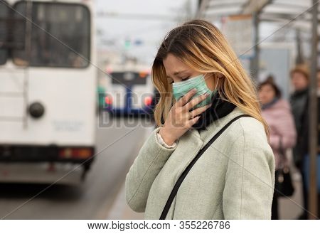Sad Caucasian Woman Wearing Sterile Protective Medical Mask Ill By The Covid-2019 Corona Virus At Th