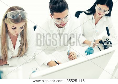 Top View.a Group Of Scientists Working On A Computer In The Labo
