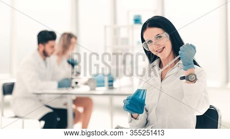Close Up.woman Scientist Takes A Sample Of The Liquid .
