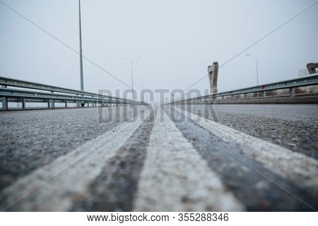 The Dividing Line On The Road Is White The View From Below On The Road Paved Going. Road Markings On