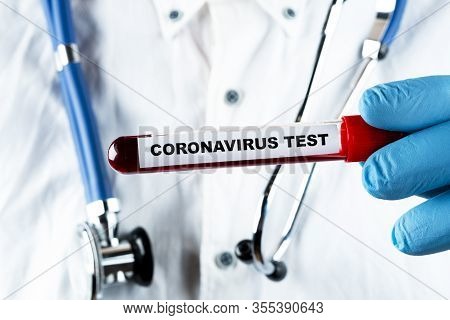 Coronavirus Blood Test Concept. Analyzing Blood Sample In Test Tube For Coronavirus Test In Doctor H