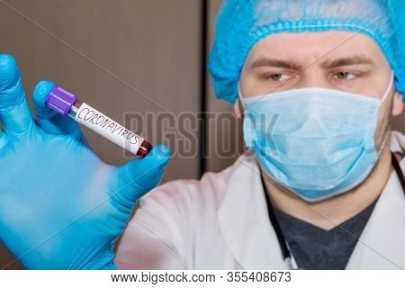Doctor Wearing Face Mask Holding A Positive Blood Test Result For The New Rapidly Spreading Coronavi