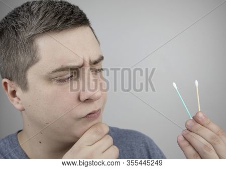Plastic And Bamboo Chisels, Toppers. A Man Chooses Between A Plastic And A Wooden Ear Stick. The Con
