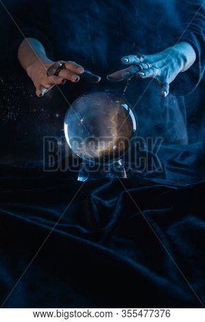 Cropped View Of Witch Performing Ritual With Crystal Ball On Dark Blue