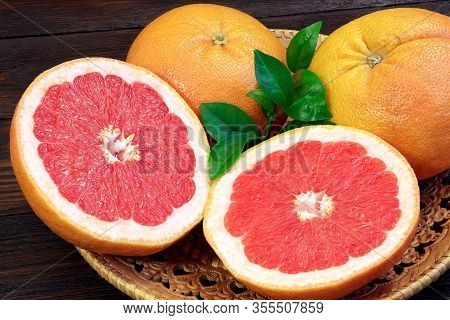 Grapefruit Fruits On A Wooden Table. Healthy Food. Brown Background. Grapefruits On A Tray.