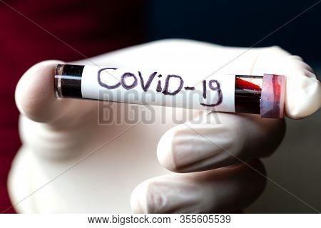 Convid-19 Blood Sample, Doctor Wearing Medical Gloves Holding A Blood Tube With Positive Coronavirus
