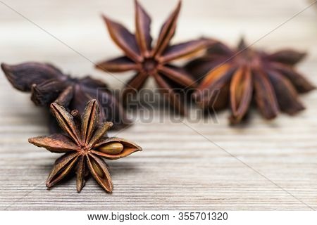Star Anise With And Without Seeds, Closed, On A Light Wooden Surface. Spice For The Recipe. Beautifu