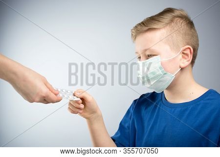 A Child In An Antiviral Mask. The Boy Drins Pills.