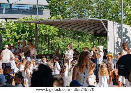 While Preparing The Kids For The Round Dance On The Dancefoor One Teacher Is Introducing The Next So