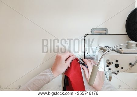 Seamstress Hands At Work, Top View. Needlewoman At Overlock Sewing Machine, Concept Of Labor