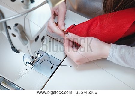 Seamstress Hands At Work. Needlewoman At Overlock Sewing Machine Doing Professional Work, Concept Of