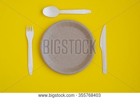 Eco- Friendly Tableware For Food And Wooden Eco-knife, Fork, Spoon On A Yellow Background With A Cop