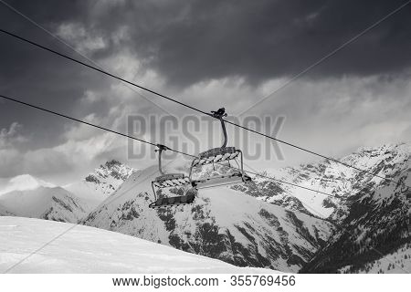 Chair Lift, Snowy Ski Slope, High Winter Mountains And Dark Cloudy Sky. Ski Area Mottolino Fun Mount