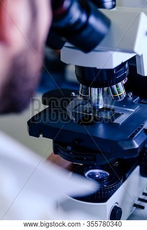 Scientific Handling A Light Microscope Examines A Laboratory Sample For Pharmaceutical Bioscience Re