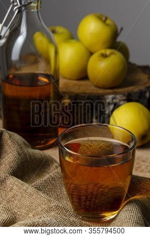 Full Bottle Of Cider With Basket Of Yellow Apples.