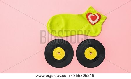 Womens Sports Sock On Two Vinyl Discs On A Pink Background. The Concept Of Music And Sports. Flat La