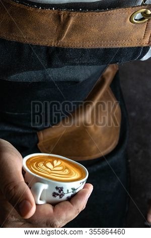Latte Art Capuccino Ina Hand Of Barista. Coloure Cup Of Fresh Coffee With Milk