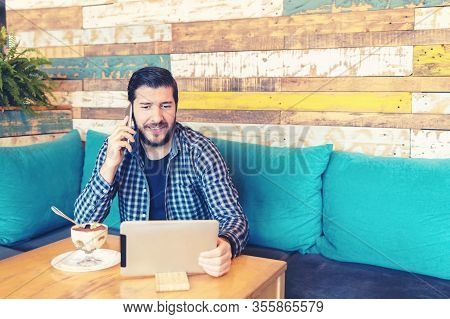 Happy Mature Bearded Entrepreneur Doing Remote Job Talking On Mobile Phone While Working On Digital 