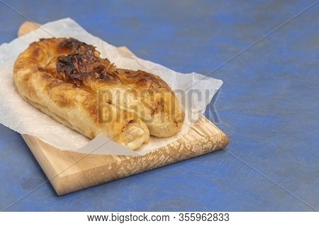 Traditional Bulgarian Cheese Pastry Banitsa On Wooden Board On Dark Blue Background