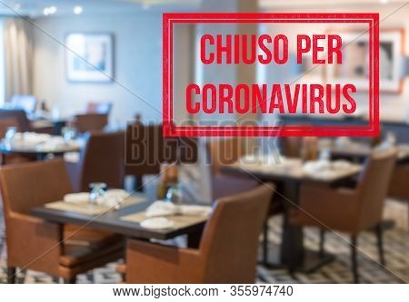 Defocused View Of Interior Of An Upmarket Restaurant Empty And Closed With Italian Notice Saying Clo