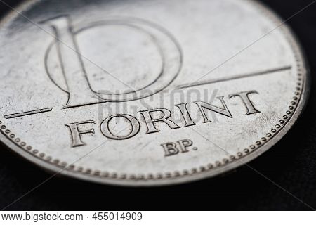 Hungarian Coin Of 10 Forints Lies On A Dark Black Surface Closeup. Money Of Hungary. News About Econ