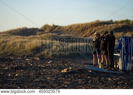Whanganui New Zealand - April 9 2022; Silhouette Landscape And Beach-goers At Dusk Enjoying Last Of 