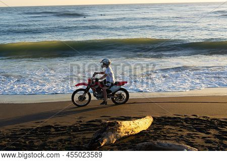 Whanganui New Zealand - April 9 2022; Motorcyclist Speeding Along Waterline On Castlecliff Beach At 