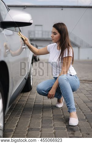 Front View Of Attractive Happy Joyful Female Driver Washing Her Car With Special Rag In Self-service