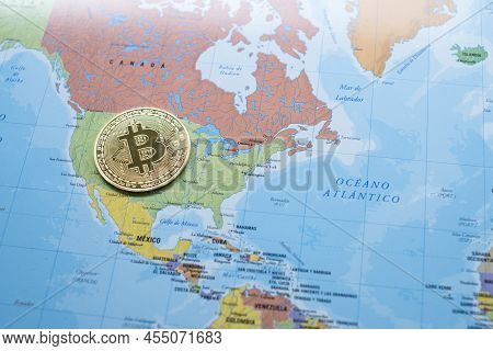 A Bitcoin Coin On A Political Map Of North America, On The Territory Of The United States, Use Of Cr
