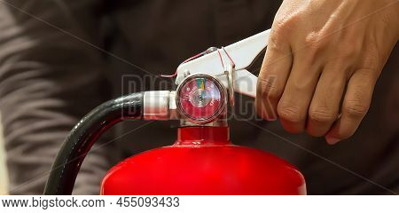 Fire Protection Engineer Check The Handle Of Red Fire Extinguishers Tank At The Exit Door In The Bui
