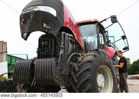 Belarus, Vitebsk, July 31, 2020. Farmer Mechanic Repairs Tractor Engine. Agricultural Machinery Repa