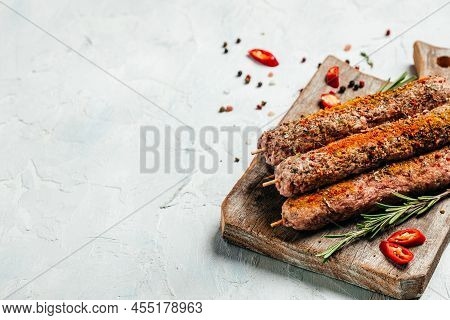 Raw Lula Kebab On Skewers With Spices On Plate Wooden Board On A Light Background. Place For Text, T