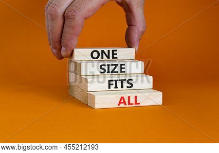 One Size Fits All Symbol. Concept Words One Size Fits All On Wooden Blocks. Businessman Hand. Beauti