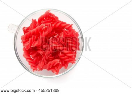 Close-up Background Of Fusille And Rotini In A Glass Bowl On White. Pasta