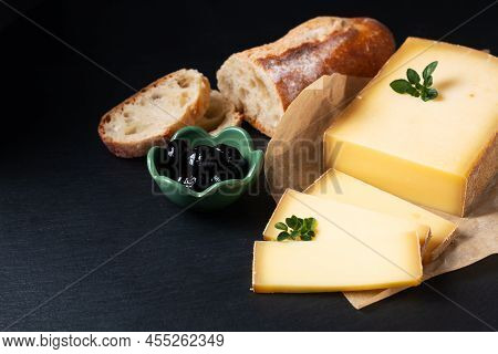 Food Concept Organic French Comté Cheese With French Bread Baquette On Black Slate Stone Board With 