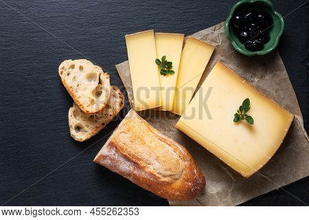 Food Concept Organic French Comté Cheese With French Bread Baquette On Black Slate Stone Board With 