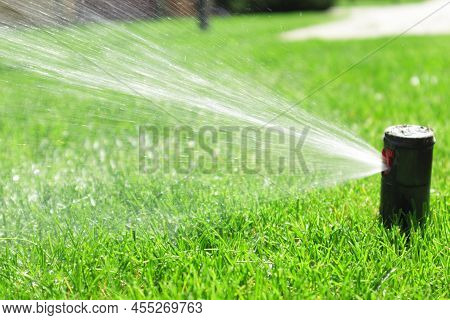 Garden Irrigation System Lawn. Automatic Lawn Sprinkler Watering Green Grass. Selective Focus.