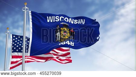 The Wisconsin State Flag Waving Along With The National Flag Of The United States Of America. Wiscon