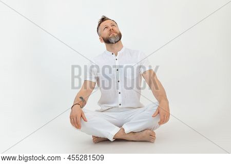 Bearded Sporty Handsome Man Tutor Sit In Lotus Posture, On White Background. Yoga Zen And Eastern Ph