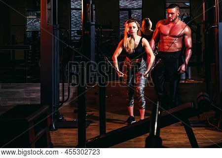 Sporty Couple Workout In Gym. Muscular Trainer Man Training Woman. Personal Trainer Fitness Instruct