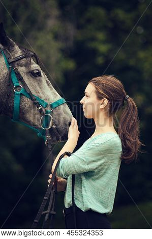 Young Girl With Grey Horse Looking At Each On. Portrait Close Up.