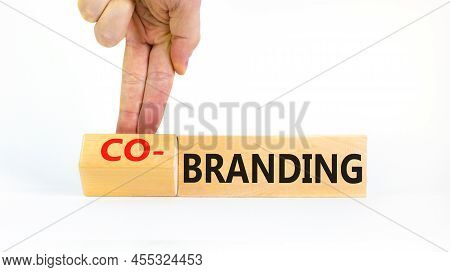 Branding Or Co-branding Symbol. Businessman Turns Wooden Cubes And Changes The Word Branding To Co-b