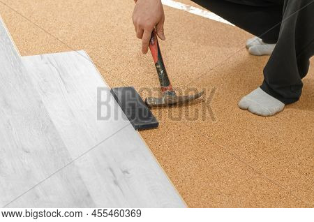 The Process Of Laying Laminate Flooring. Unrecognizable Man Laying Laminate Flooring. Repair In The 