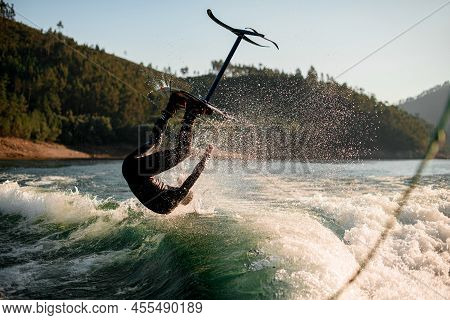 Amazing View On Man Jumping And Flips On Foil Wakeboard Over Splashing Wave