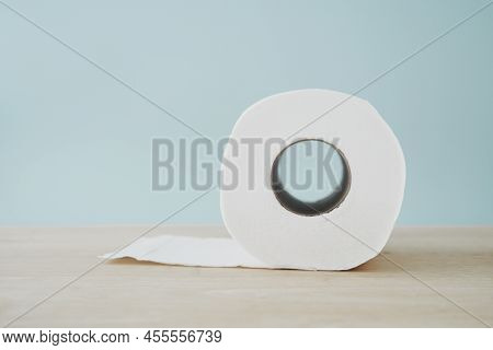 Roll Of Hygiene White Tissue Paper On Wooden Desk In Soft Focus