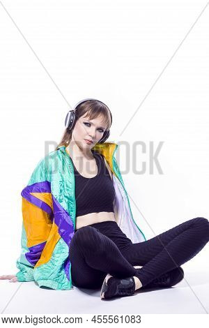 Modern Lifestyle. Sitting Caucasian Female Athlete Sportwoman In Fitness Sexy Outfit Wearing Wireles