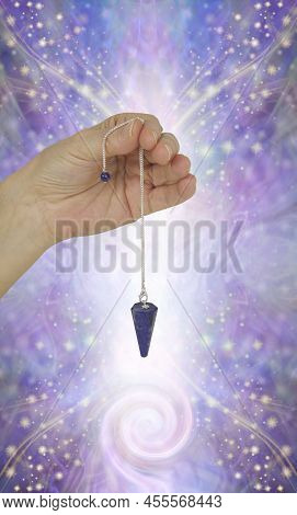 Dowsing With Spiral Energy Field - Female Hand Holding Lapis Lazuli Dowsing Pendant Against Beautifu