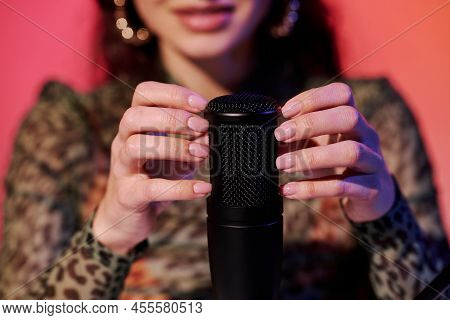 Selective Focus Of Young Blogger Sitting In Studio In Pink And Yellow Neon Light Recording Sounds Fo