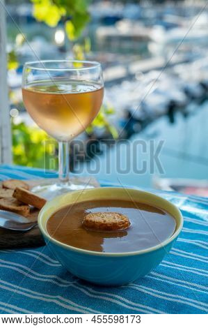 Homemade Fish Soup With Croutons Served With Glass Of Cold Rose Wine And View On Colorful Fisherman'