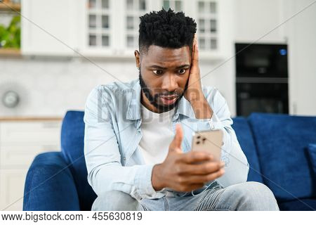 Upset Brunette Young Man Holding Smartphone, Looking With Disappointment Face Expression At Phone Sc